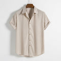 Beige striped shirt on a hanger against a white background