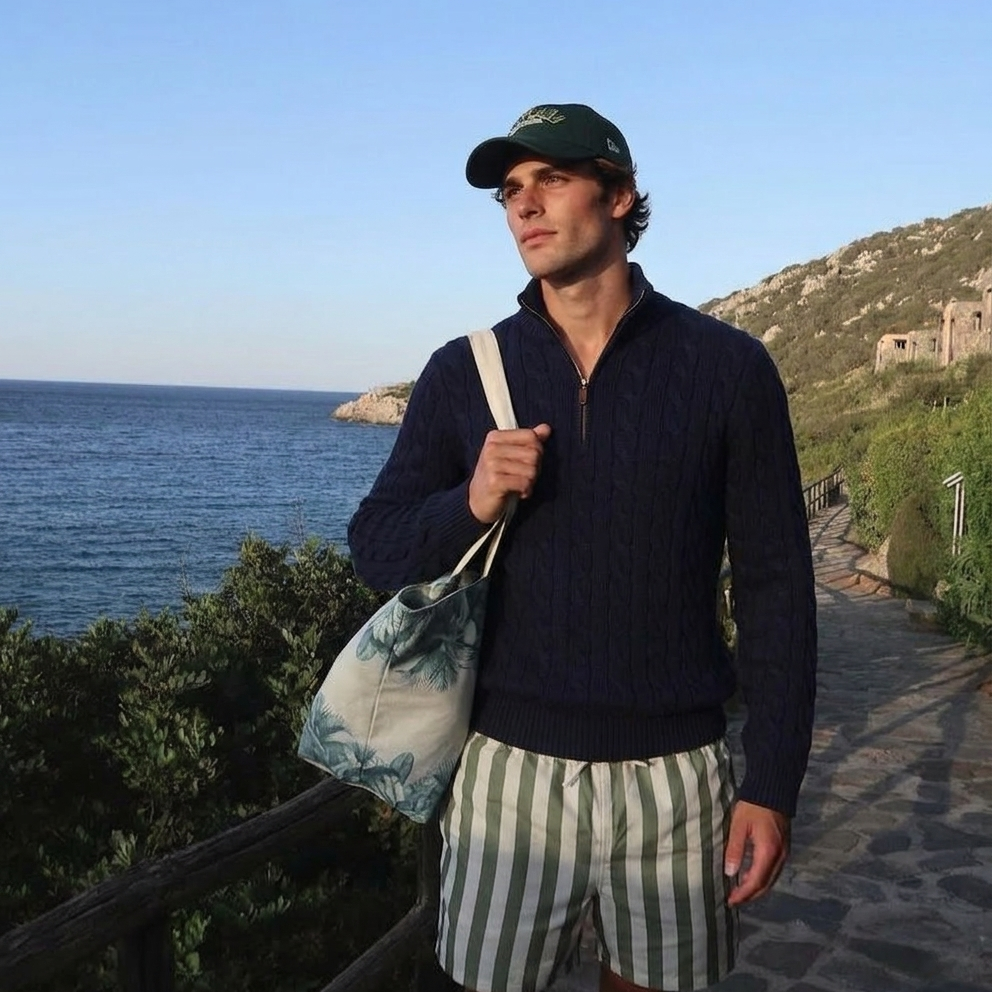 Man standing by the ocean with a scenic background