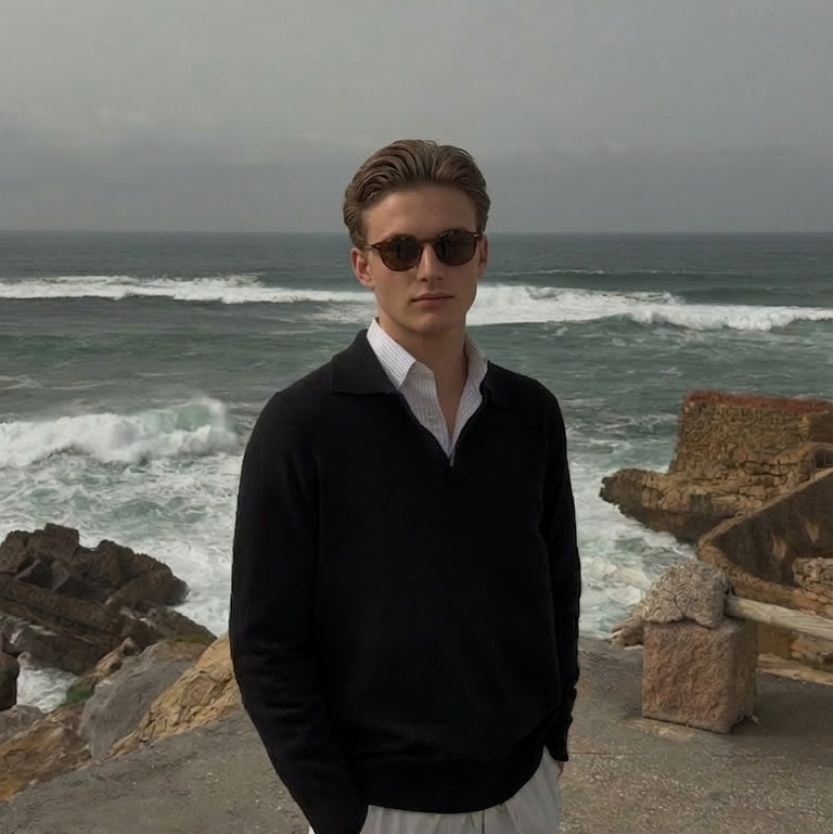 Man standing on a rocky coastal area with ocean waves in the background