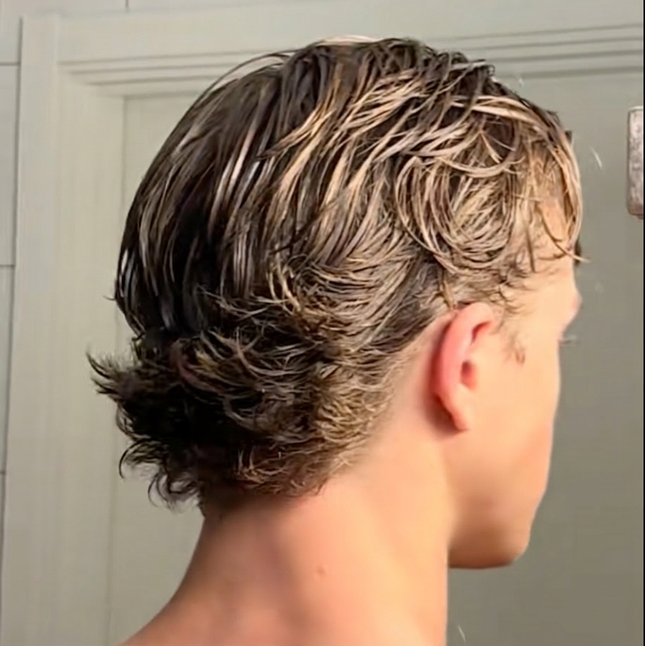 Person with wet European flow style hair in a bathroom setting