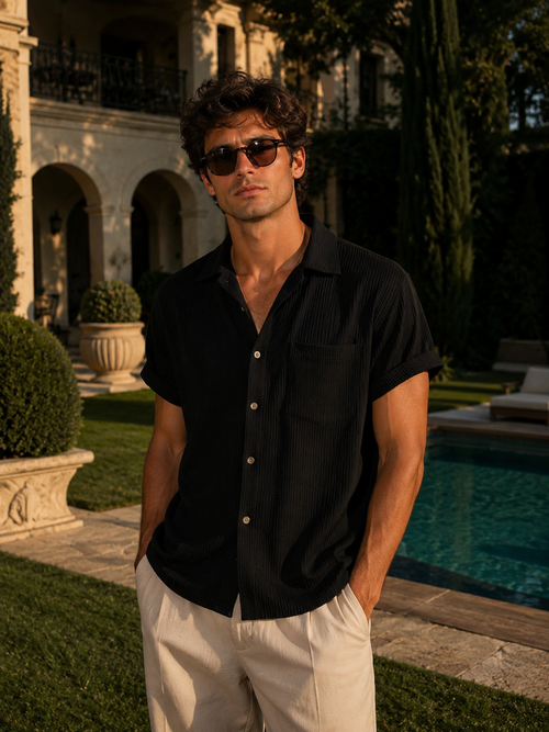 Man wearing sunglasses and a black shirt by a poolside