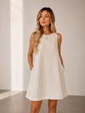 Woman wearing a white dress against a plain background